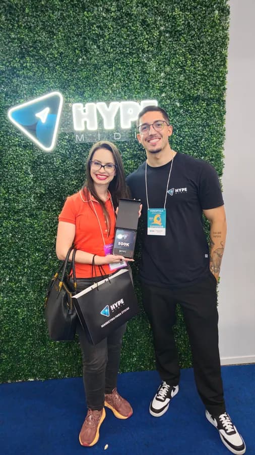 Cliente com a placa de 500 mil em faturamento diante do letreiro da Hype Mídia